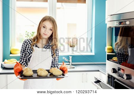 Housewife Holding Hot Roasting Pan With  Freshly Baked Bread Rolls.
