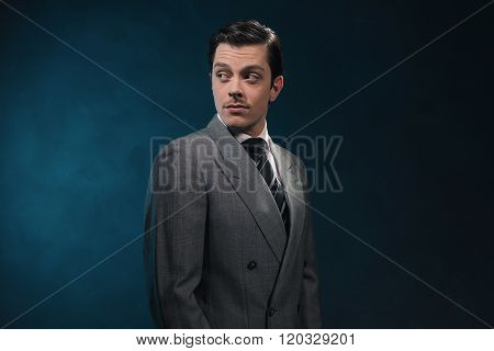 Retro 1940S Business Man In Suit And Tie Against Blue Wall.