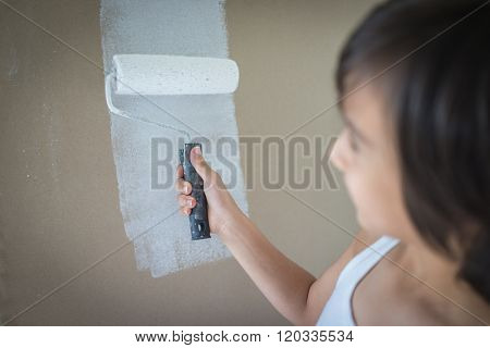 Little cute boy painting on a wall