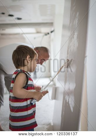 Little cute boy painting on a wall