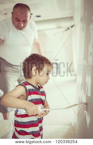 Little cute boy painting on a wall