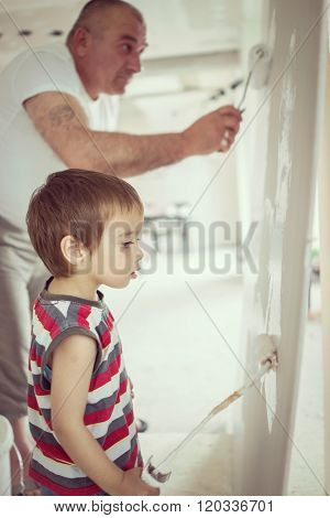 Little cute boy painting on a wall