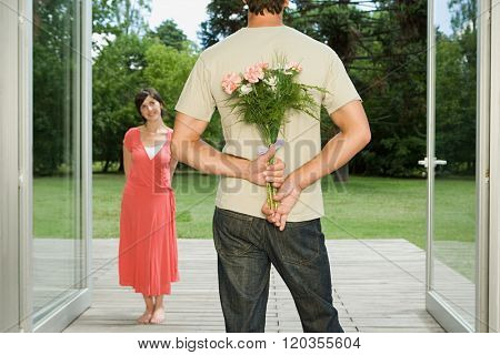 Man surprising wife with flowers