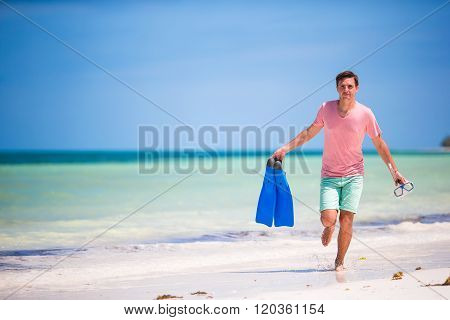 Young man with mask and fins. Holiday vacation on a tropical beach.