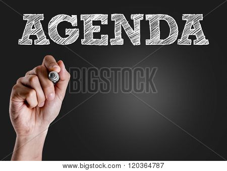 Hand writing the text: Agenda