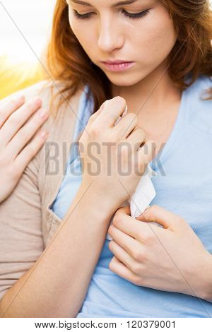 friendship, support, heartbreak and people concept - close up of crying teenage girl comforted by friend