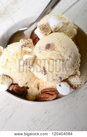 Bowl of delicious butter pecan ice cream with toasted pecans and marshmallows