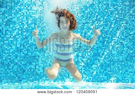 Girl jumps, dives and swims in pool underwater, happy active child has fun under water, kid sport