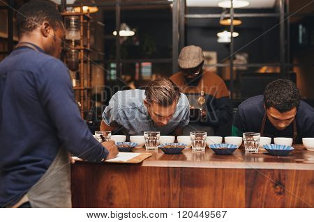 Barista training with rows of different coffees in roastery