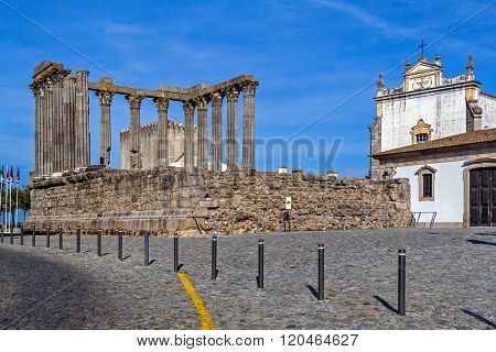 Evora, Portugal. The iconic Roman Temple dedicated to the Emperor cult, wrongly considered as a Goddess Diana Temple, with the Loios Convent used as a Historical Hotel. UNESCO World Heritage Site.
