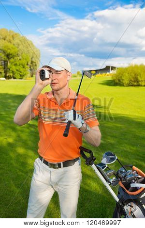 man golfer watching into rangefinder