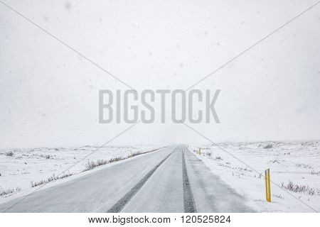 Snow falling on a country road in iceland in the winter