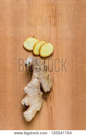 Sliced fresh ginger root on wooden table