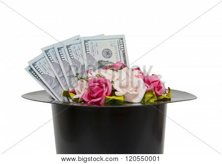 Money and flowers in black magic hat isolated on a white backgroundm