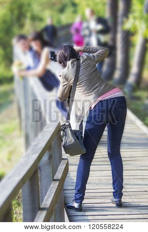 Wedding Photographer Taking Photographs Of Groom And Bride
