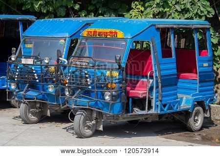 RISHIKESH INDIA - OCTOBER 20 2014 : Auto rickshaw taxis on a road. These iconic taxis have recently been fitted with CNG powered engines in an effort to reduce pollution