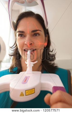 Close-up photo of young woman having dental panoramic x-ray with digital equipment.