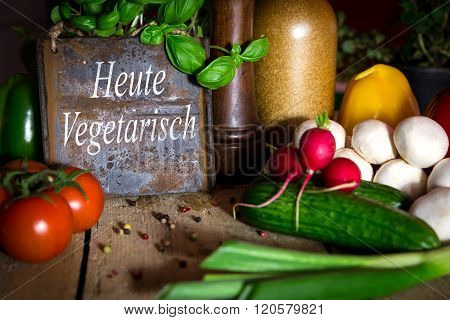 A Lots Of Healthy Vegetables On A Wooden Table, Sign With Text Heute Vegetarisch