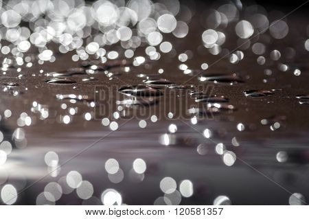 Nise texture and light reflection in raindrops on a roof of a car