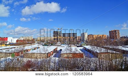 Under construction multi-storey building on a background of single-storey houses
