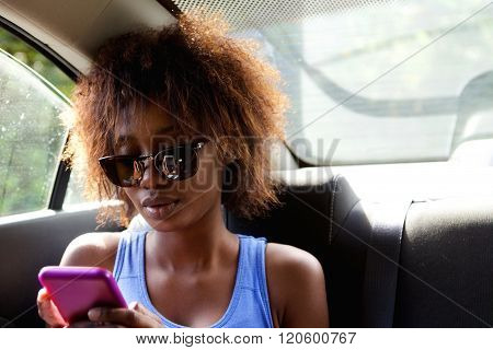 Young Woman Sitting N Backseat Of Car Looking At Cell Phone