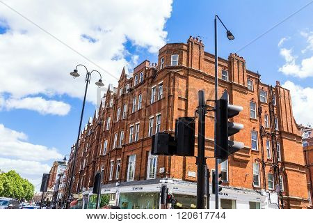 LONDON UK - JUNE 6 2015: Unidentified people and traffic on typical English Brompton road in a summer afternoon