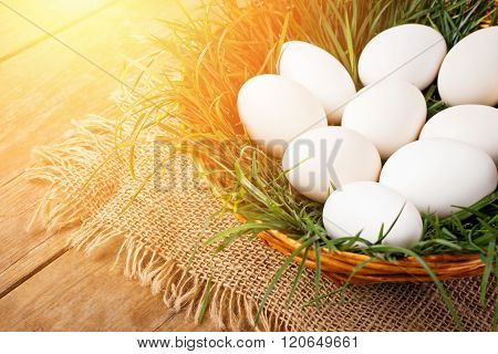 Easter eggs in brown basket with grass
