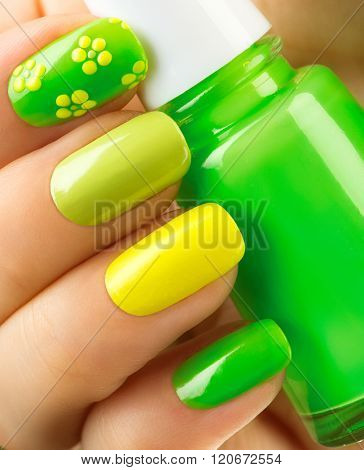 Spring green manicure. Fresh Nature trendy green nails. Beautiful nail polish with grass. Green and yellow colors Eco Nail art manicure. Bottle of Nail Polish. Fashion Beauty hands. Stylish Nailpolish
