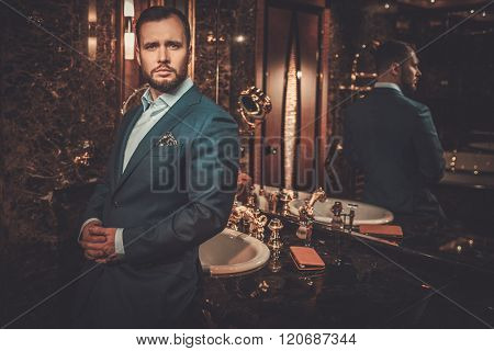 Confident well-dressed man in luxury bathroom interior.