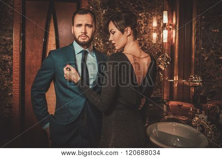 Well-dressed couple in luxury bathroom interior.