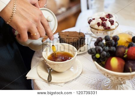 man pouring english tea in cup