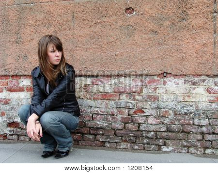 Niña sentada junto a la pared del Grunge
