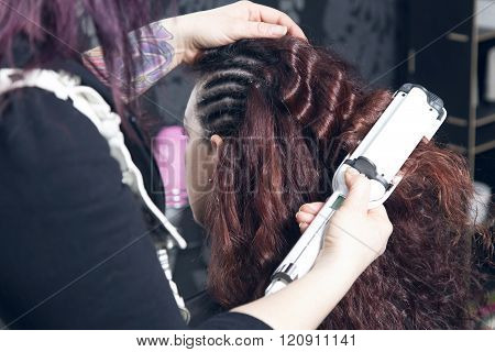 Hairdresser Ironing One Customer's Curled Hair.