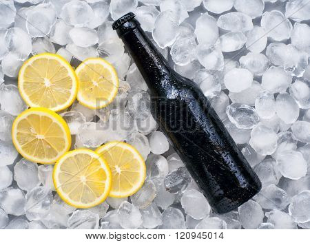 Dark Beer Bottle With Lemon Slices In The Ice