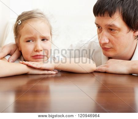 Father comforts a sad girl. Problems in the family