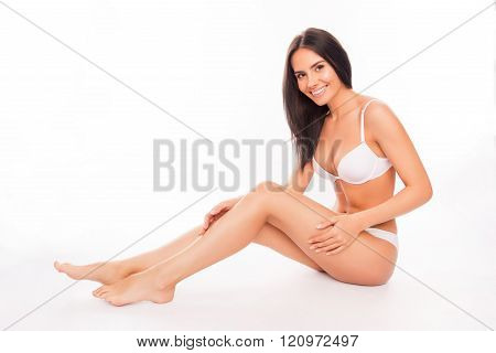 Happy Woman In Lingerie Sitting And  Touching Her Smooth Legs