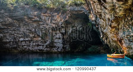 small boat inside a cave lake with blue water in kefallonia greece