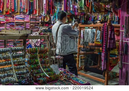 POKHARA, NEPAL - September 29, 2013: Tourists buying souvenirs in a shop. Original regional jewelery from Nepal. Pokhara streets.