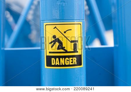 Warning sign on agricultural machinery. Before performing work under the inclined chamber and reel, it is necessary to fix the lifting cylinders with the help of the existing locking elements