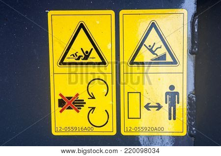 Warning sign on farm machinery. Before working under feeder housing is necessary to fix the lifting cylinders. Winding is possible. Do not climb. Observe the distance.