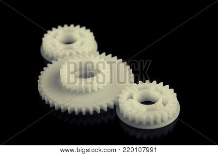 Three plastic gears on a black background.
