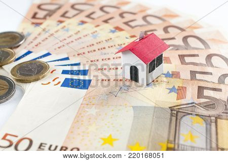 Paper house on a fifty euros banknote fan: mortgage and loan concept