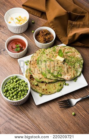 Green peas stuffed paratha or matar ka paratha, which is a traditional and popular food native to north India, made from dough of wheat flour and green peas or matar, served with mango pickle, curd bundi etc