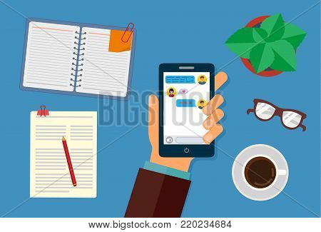 Hand holding smartphone with text messages on the screen. On the desktop, Notepad, pen, flower, coffee Cup and papers. The view from the top. Vector illustration.