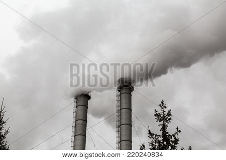 The smoke from the chimneys of the CHP. Pollution of the environment. Environmental disaster.