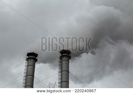 The smoke from the chimneys of the CHP. Pollution of the environment. Environmental disaster.