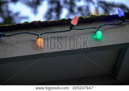 christmas lights on a string hang outside in the evening with copy space.