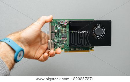 PARIS, FRANCE - NOV 6, 2017: Man hand holding against gray background powerful NVIDIA GPU video card from the Quadro line used in professional video production in bitcoin cryptocurrency mining