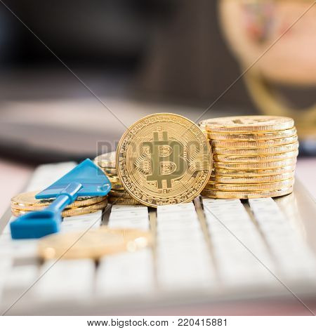 Bitcoin cryptocurrency on keyboard with gold stack coins of virtual digital currency for fintech financial banking business and world stock exchange investment via internet online computer technology concept
