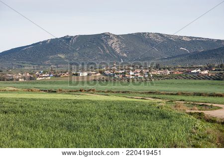 Small hamlet in an agricultural landscape in La Mancha, Ciudad Real Province, Spain. In the background can be seen the Toledo Mountains